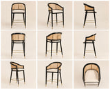Levanto Kitchen Bar Stool Chair in black wood with natural rattan backrest, cream upholstered seat and brass accents in a luxury beige kitchen interior.