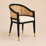 Levanto Dining Chair in black wood with natural rattan backrest and cream upholstered seat in a luxury dining interior.