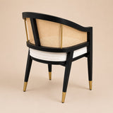 Levanto Dining Chair in black wood with natural rattan backrest and cream upholstered seat in a luxury dining interior.