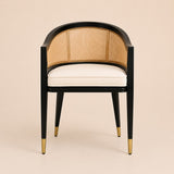 Levanto Dining Chair in black wood with natural rattan backrest and cream upholstered seat in a luxury dining interior.