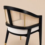 Levanto Dining Chair in black wood with natural rattan backrest and cream upholstered seat in a luxury dining interior.
