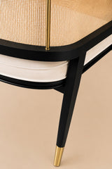 Levanto Dining Chair in black wood with natural rattan backrest and cream upholstered seat in a luxury dining interior.