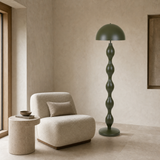 Olive green sculptural floor lamp styled in a Mediterranean minimalist reading corner