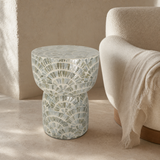 Aria mother-of-pearl mosaic stool beside a cream lounge chair