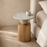 Assisi Marble & Timber Side Table alternate angle beside a linen bed