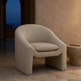 Bergamo cream upholstered armchair in a refined blue-hour interior