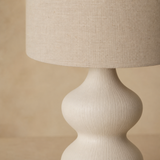 Close-up of the linen shade and sculptural ivory finish of the Bondi Rattan Lamp