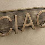 Close-up of the distressed antique metal finish and raised Ciao lettering