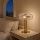 Deluca gold metal and ribbed glass lamp illuminated at blue hour