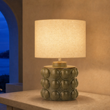 Drift olive resin table lamp glowing in a Mediterranean villa at blue hour