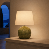 Drift Medium olive resin globe lamp glowing in a Mediterranean villa at blue hour