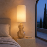 Koda Rattan Lamp illuminated in a minimalist Mediterranean bedroom