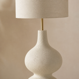 Close-up of the textured resin, brass stem and linen shade of the Lido floor lamp