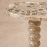 Primer plano del mármol brecha y pedestal lobulado de la mesa Lucca