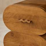 Lugano bedside table close-up showing natural walnut grain and sculptural wavy wood handle