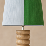 Marco lamp close-up showing sky and emerald textile with natural wood grain