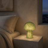 Green mushroom glass LED lamp glowing softly at blue hour