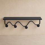 Oriel black metal wall shelf and four-hook rack, warm beige studio view
