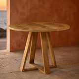 Oristano round natural timber table in a warm evening interior