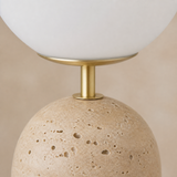 Close-up of Palma travertine brass and opal glass finishes