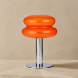 Peyton orange glass and chrome table lamp in a warm beige Elara studio