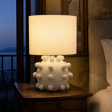 Pip ivory bobble ceramic table lamp in an elegant evening bedroom