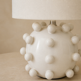 Close-up of the Pip ivory ceramic bobble finish and linen shade