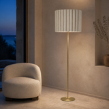 Sombra Gold floor lamp in a minimalist reading alcove at dusk