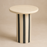 Tyra striped cylindrical side table in a warm beige studio