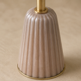 Close-up of the Venetia brushed brass collar and blush-taupe vertically fluted pedestal
