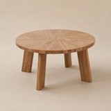 Verona round natural wood coffee table with sunburst parquet top and four chunky splayed slab legs in a warm beige studio