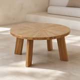 Verona round natural wood coffee table with radial sunburst top and exactly four splayed slab legs in a premium Mediterranean living room