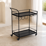Alternate lifestyle angle of the Walker all-black iron bar cart with two empty black wood-grain trays and four caster wheels