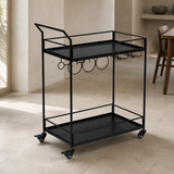 Walker all-black bar cart with two black wood-grain trays, elevated handle, bottle rings, stemware rack and four casters in a premium Mediterranean interior