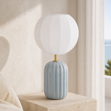 Alternate lifestyle angle of the Wilton blue-grey fluted ceramic table lamp with brass neck and ribbed white balloon shade